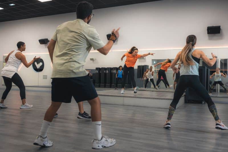Aula de dança com instrutora em estúdio de ginástica.