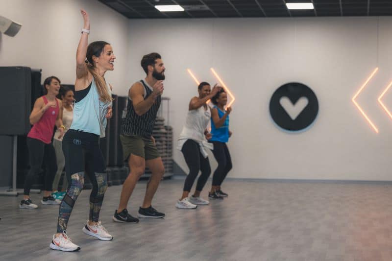 Pessoas a fazer exercício em grupo numa aula.