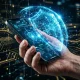 mão a segurar um smartphone com um escudo holográfico azul, simbolizando a