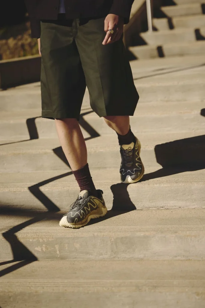 Homem com calções e sapatilhas a descer escadas de betão.