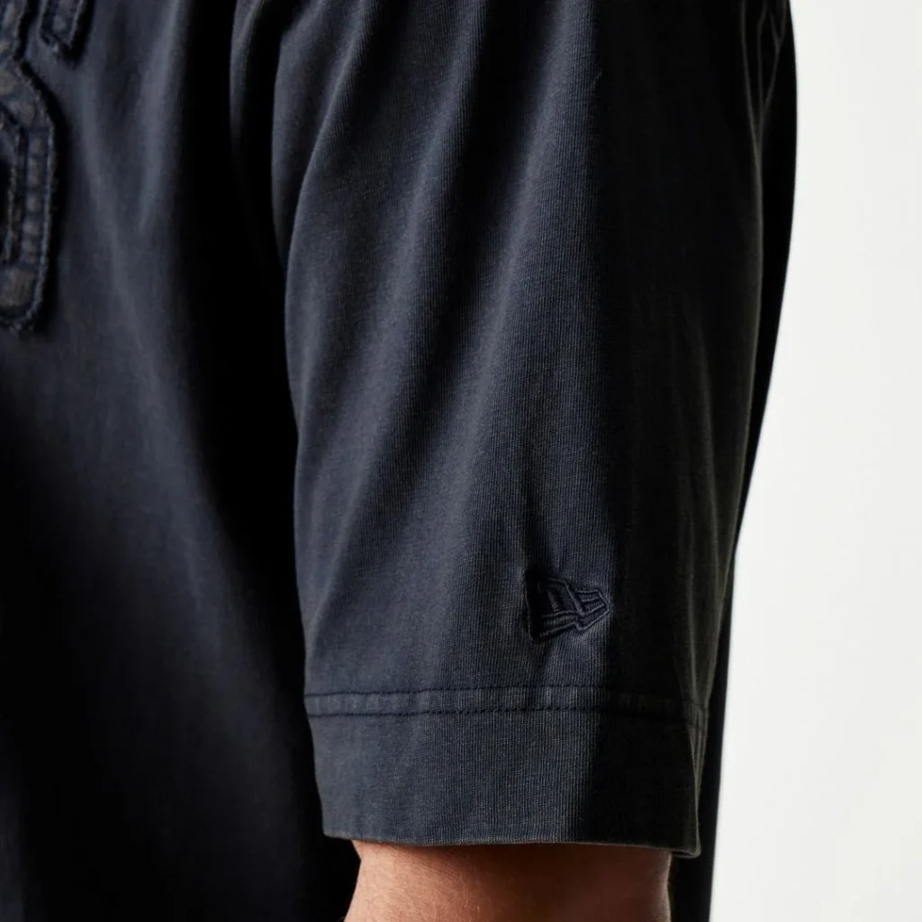 Pormenor de t-shirt preta com logo New Era