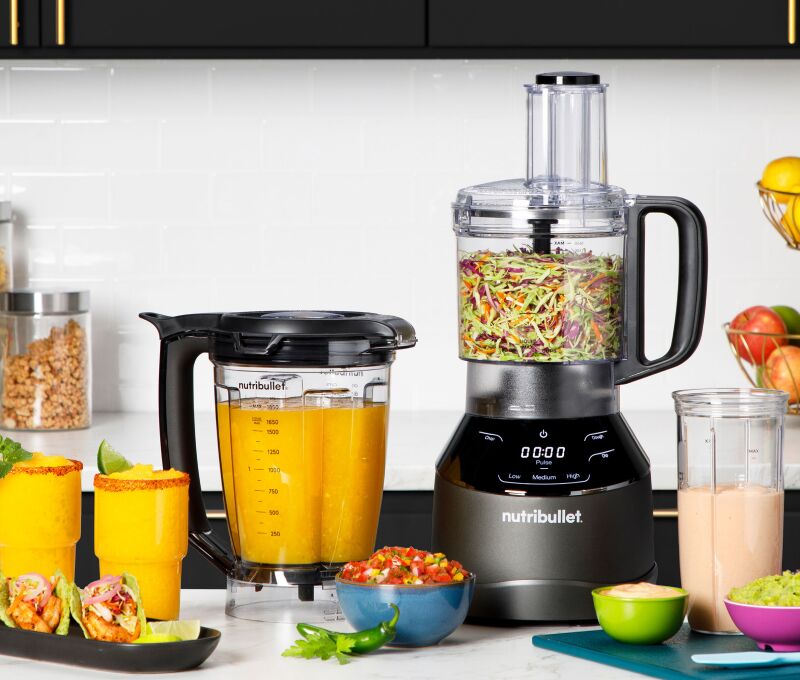 Processador de alimentos com ingredientes frescos na cozinha.