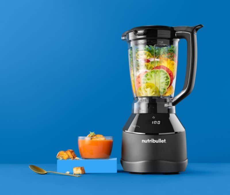 Liquidificador com frutas frescas e sopa de tomate.