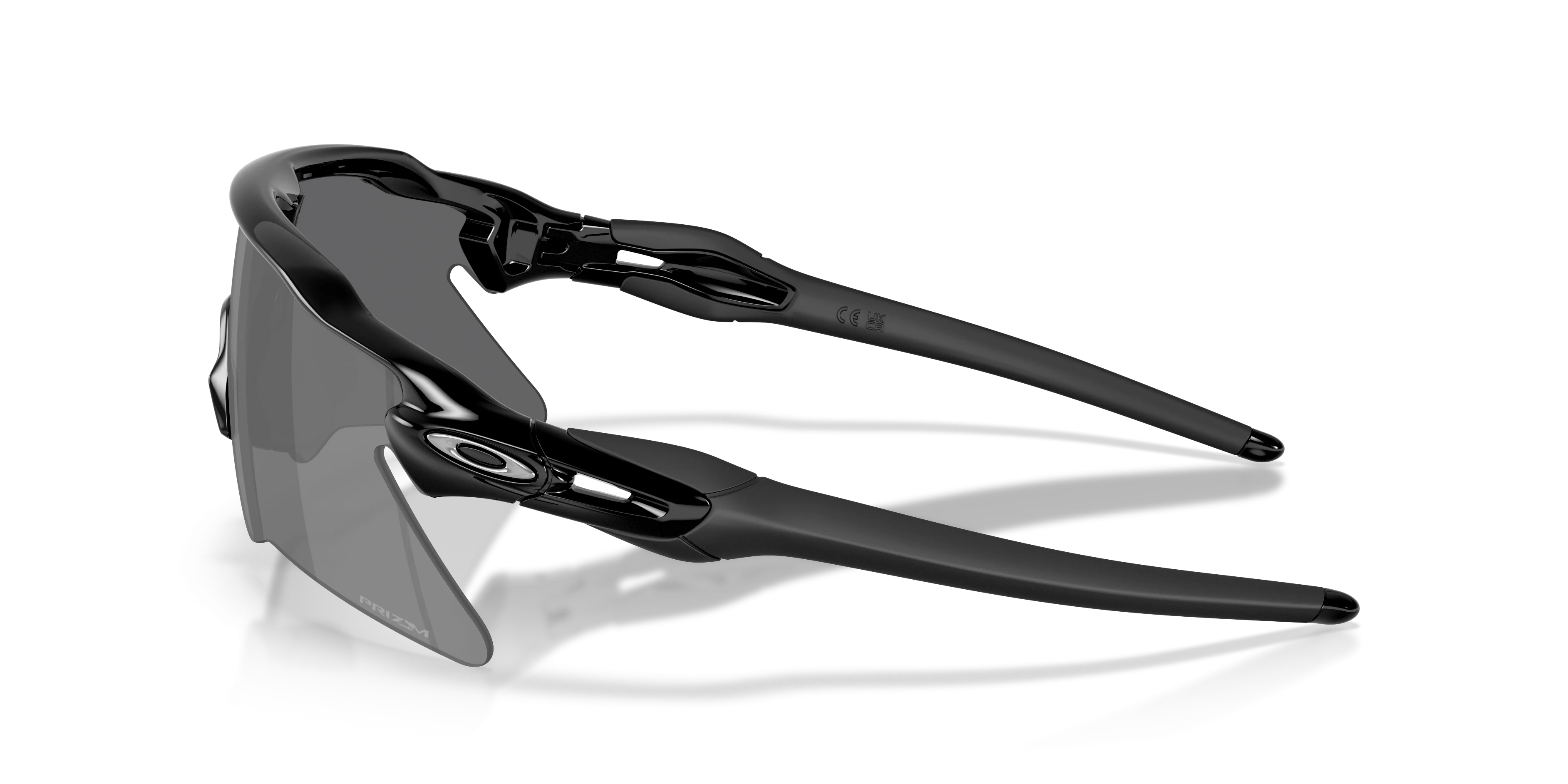Óculos de corrida Oakley Radar EV Heater pretos com lentes Prizm e hastes emborrachadas sobre fundo branco