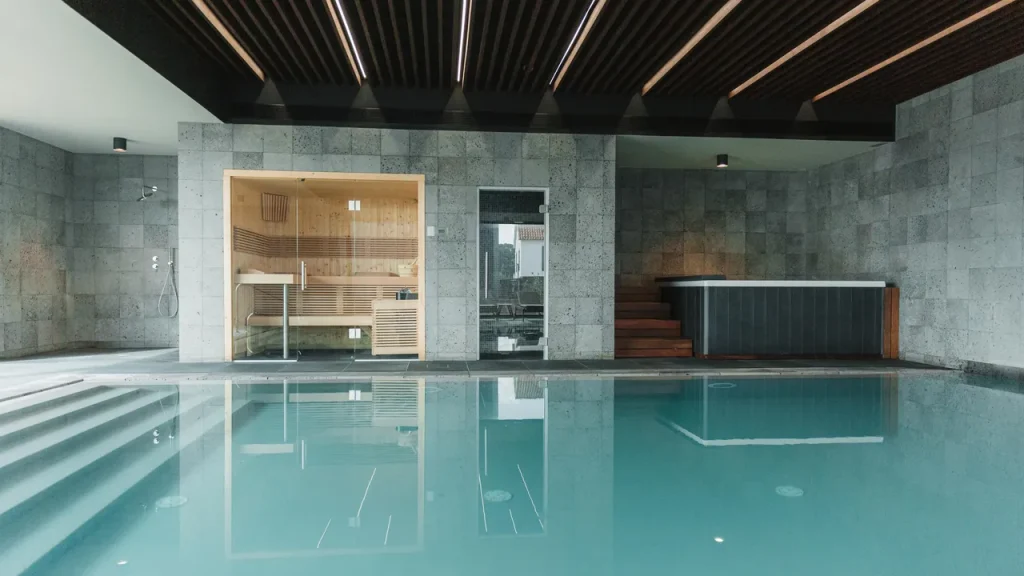 Piscina interior com sauna e jacuzzi modernos.