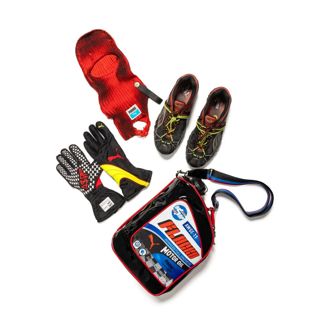 Sapatilhas PUMA Straycat A$AP Rocky pretas com atacadores duplos amarelos, luvas de corrida, balaclava vermelha e saco estilo óleo de motor sobre fundo branco