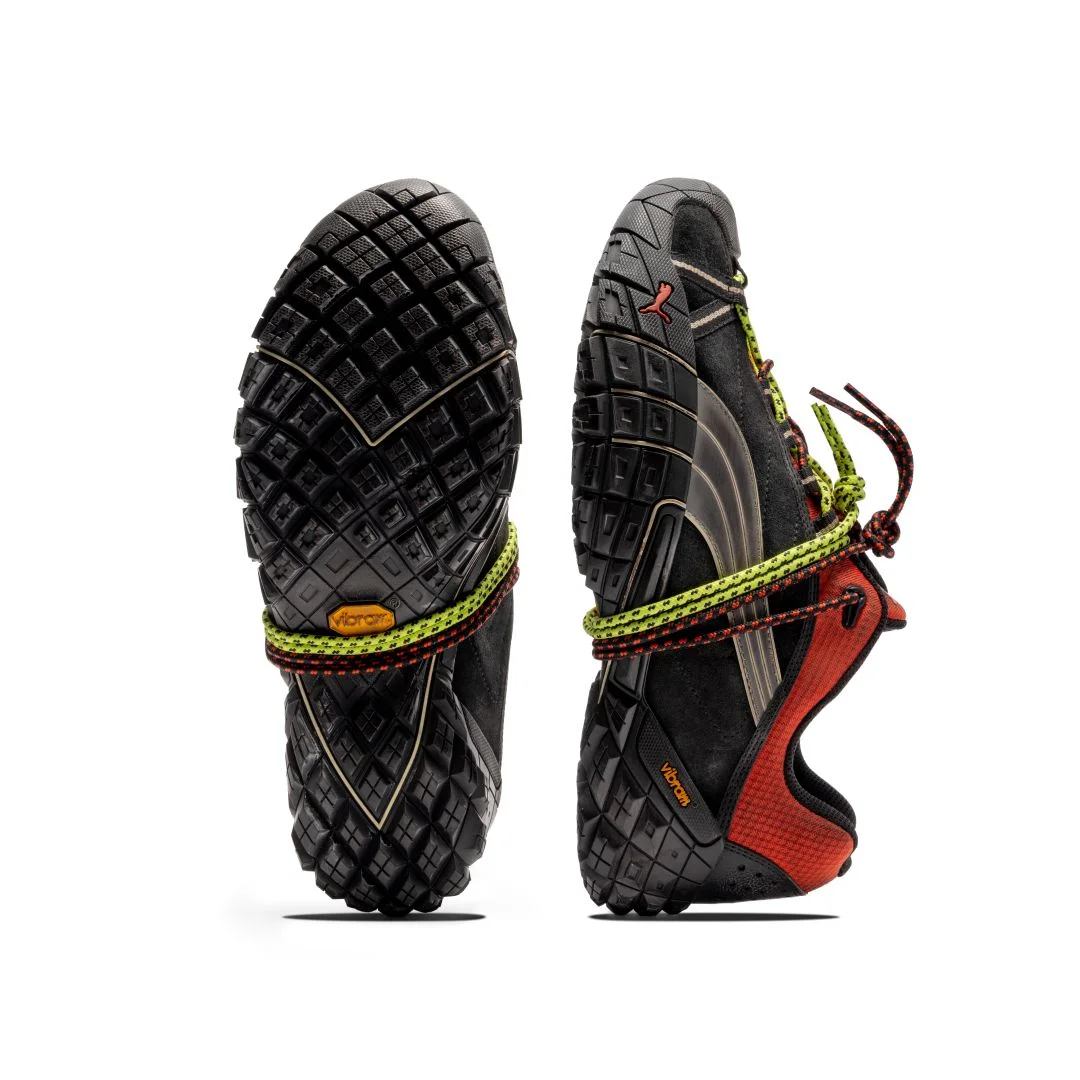 Par de sapatilhas PUMA Straycat A$AP Rocky pretas e vermelhas exibindo a sola robusta Vibram e atacadores duplos sobre fundo branco.