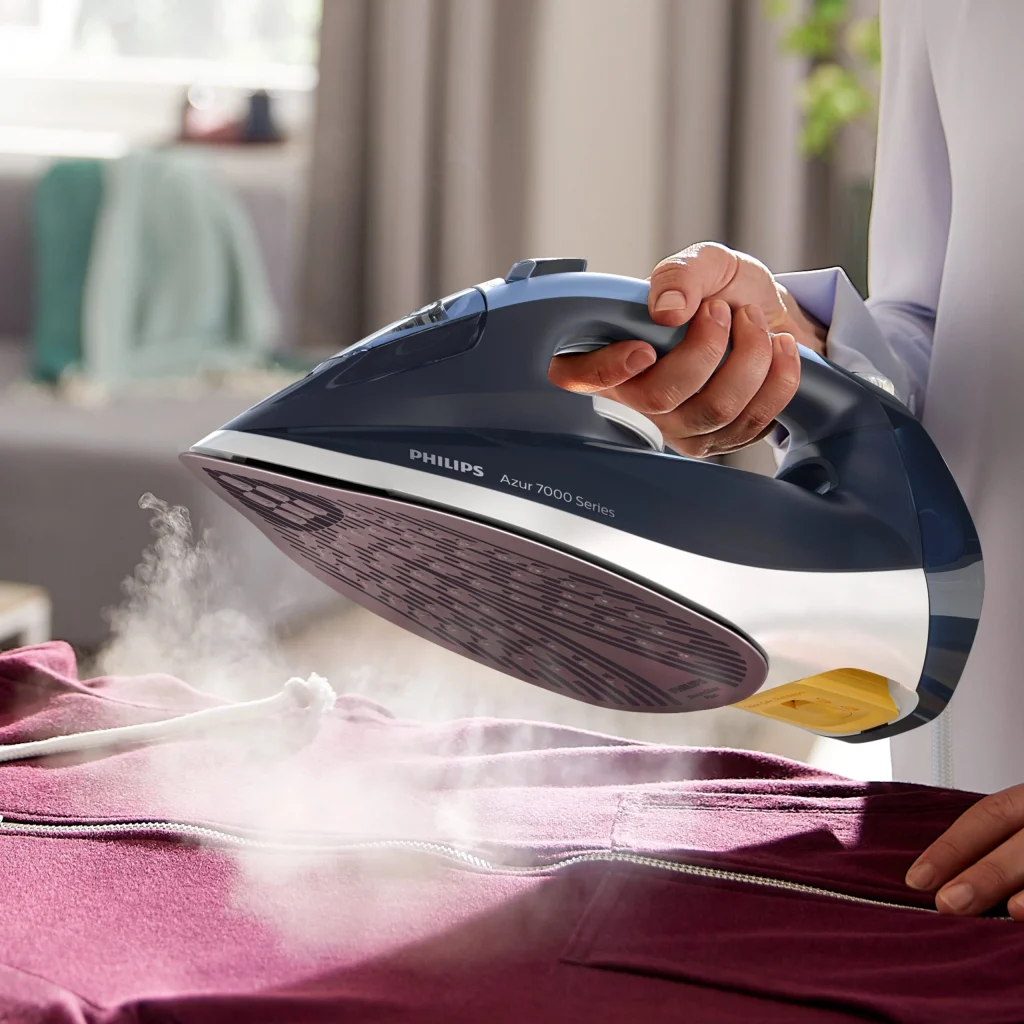 Ferro Philips Azur 7000 a deitar vapor sobre roupa roxa.