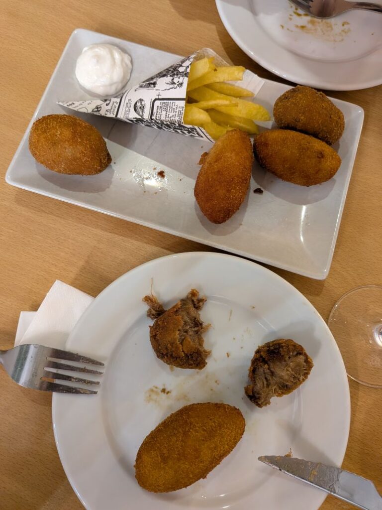 Prato de rissóis, batatas fritas e molho.
