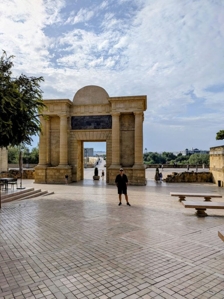 Arco de entrada histórico com céu azul aberto.