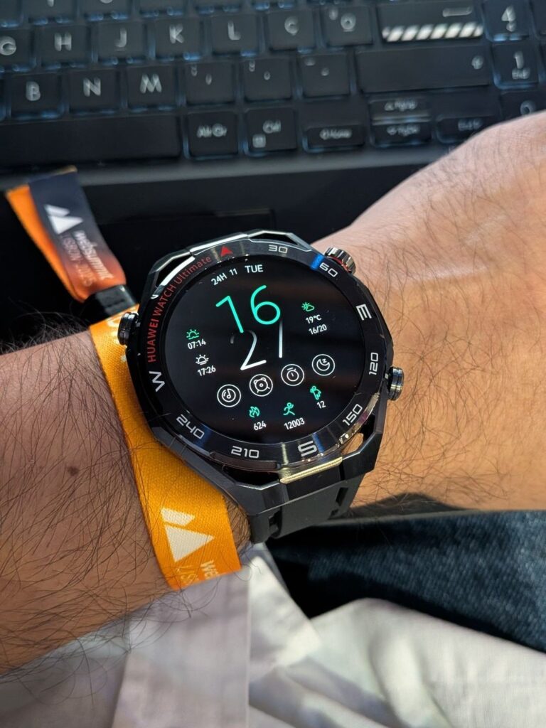 Relógio inteligente no pulso, fundo teclado computador.