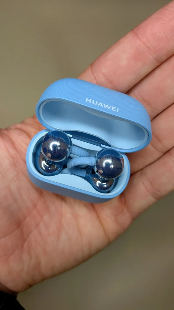 Auriculares sem fios Huawei azuis na mão.