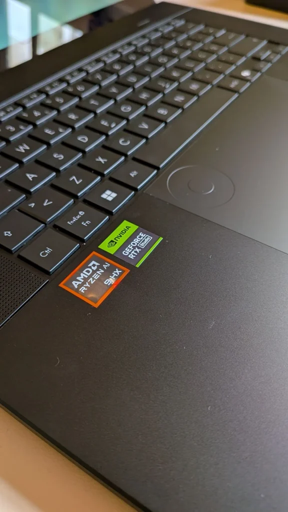 Teclado de portátil com autocolantes AMD e NVIDIA.