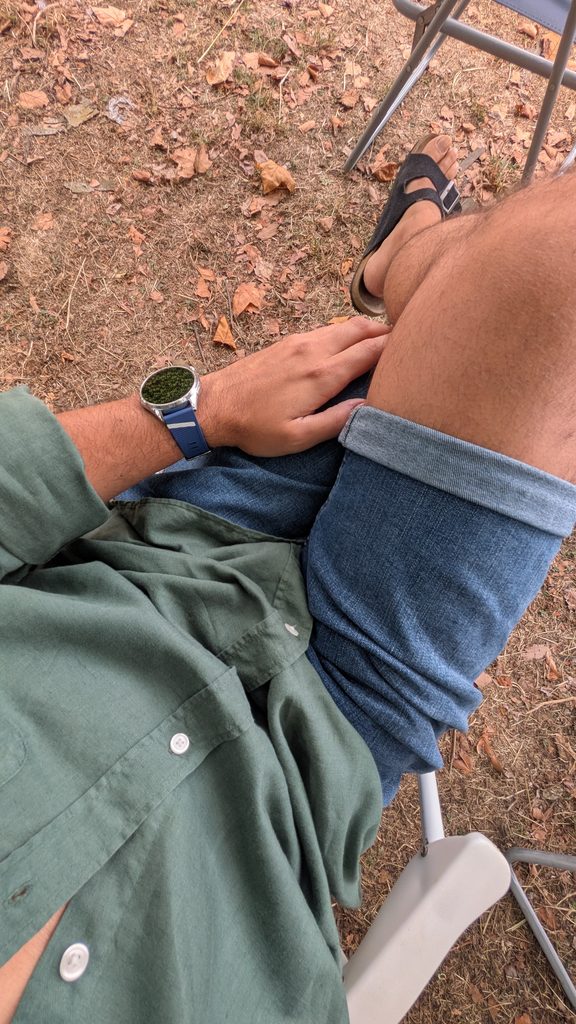 Vista superior de homem sentado ao ar livre com smartwatch.