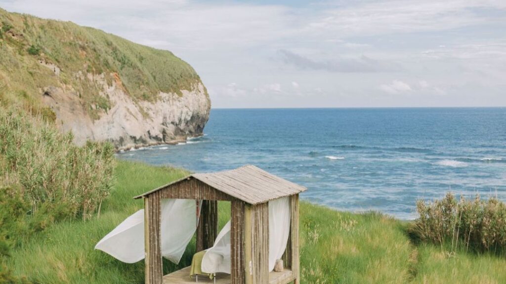 Cabana rústica à beira-mar com paisagem verde