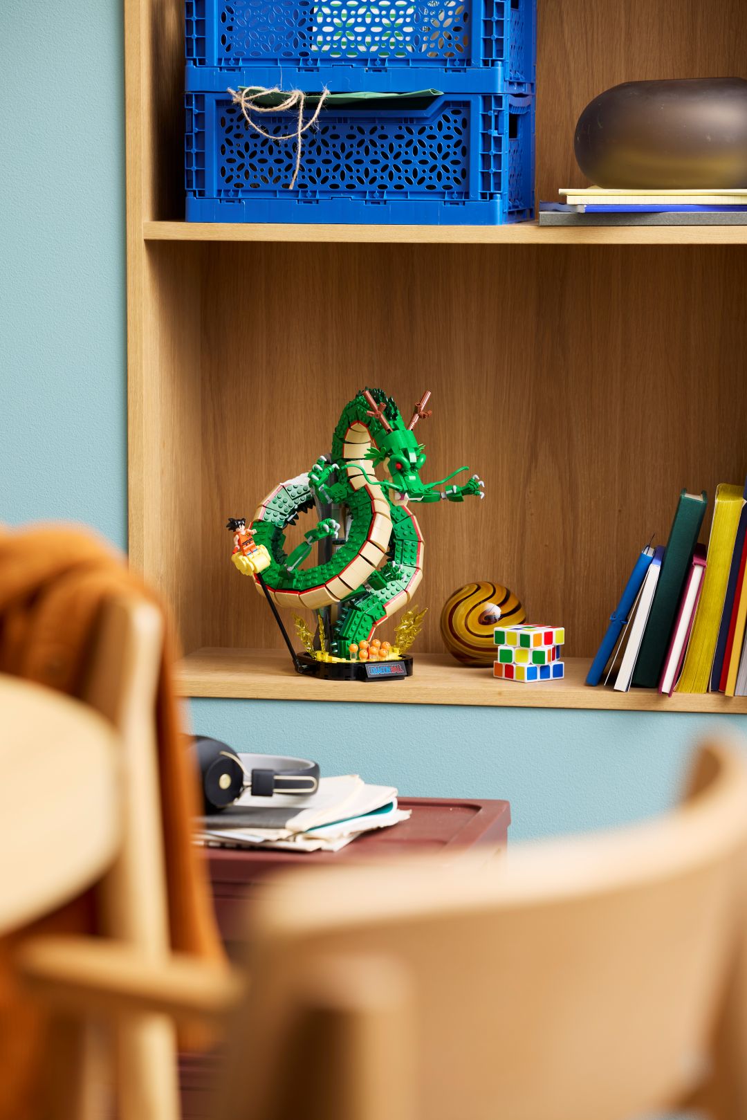 Set LEGO Dragon Ball com o dragão Shenron verde e a minifigura de Songoku na Nuvem Mágica exposto numa prateleira de madeira