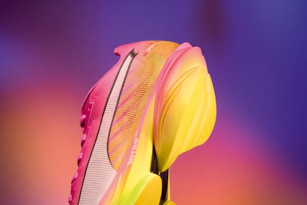 Sapatilha de corrida vibrante rosa e amarela com sola grossa.