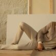 Modelo em pose casual com roupa bege elegante.