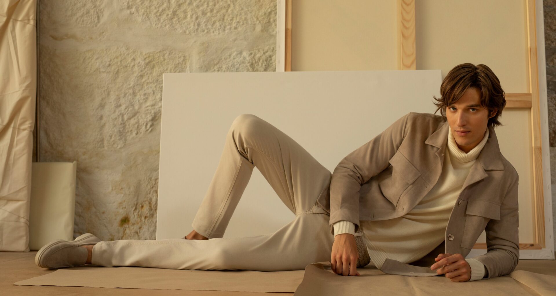 Modelo em pose casual com roupa bege elegante.