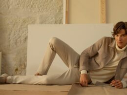 Modelo em pose casual com roupa bege elegante.