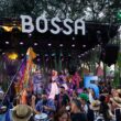 Concerto ao ar livre com banda e público animado.