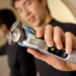 Homem a segurar máquina de barbear elétrica moderna.