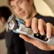 Homem a segurar máquina de barbear elétrica moderna.