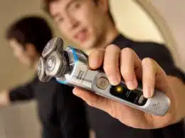 Homem a segurar máquina de barbear elétrica moderna.