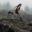 Homem a correr em montanha com neblina.
