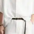 Pessoa com roupa de linho e cinto castanho.