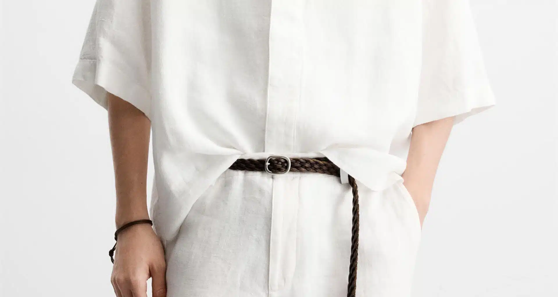 Pessoa com roupa de linho e cinto castanho.