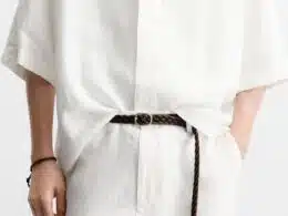 Pessoa com roupa de linho e cinto castanho.