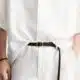 Pessoa com roupa de linho e cinto castanho.