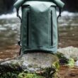 Mochila verde impermeável junto a um rio