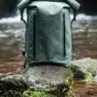 Mochila verde impermeável junto a um rio