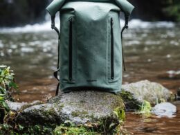 Mochila verde impermeável junto a um rio