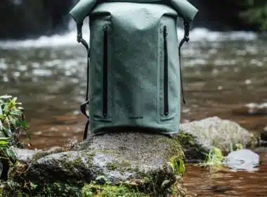 Mochila verde impermeável junto a um rio