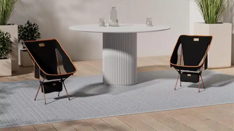 Sala com mesa redonda e duas cadeiras pretas.