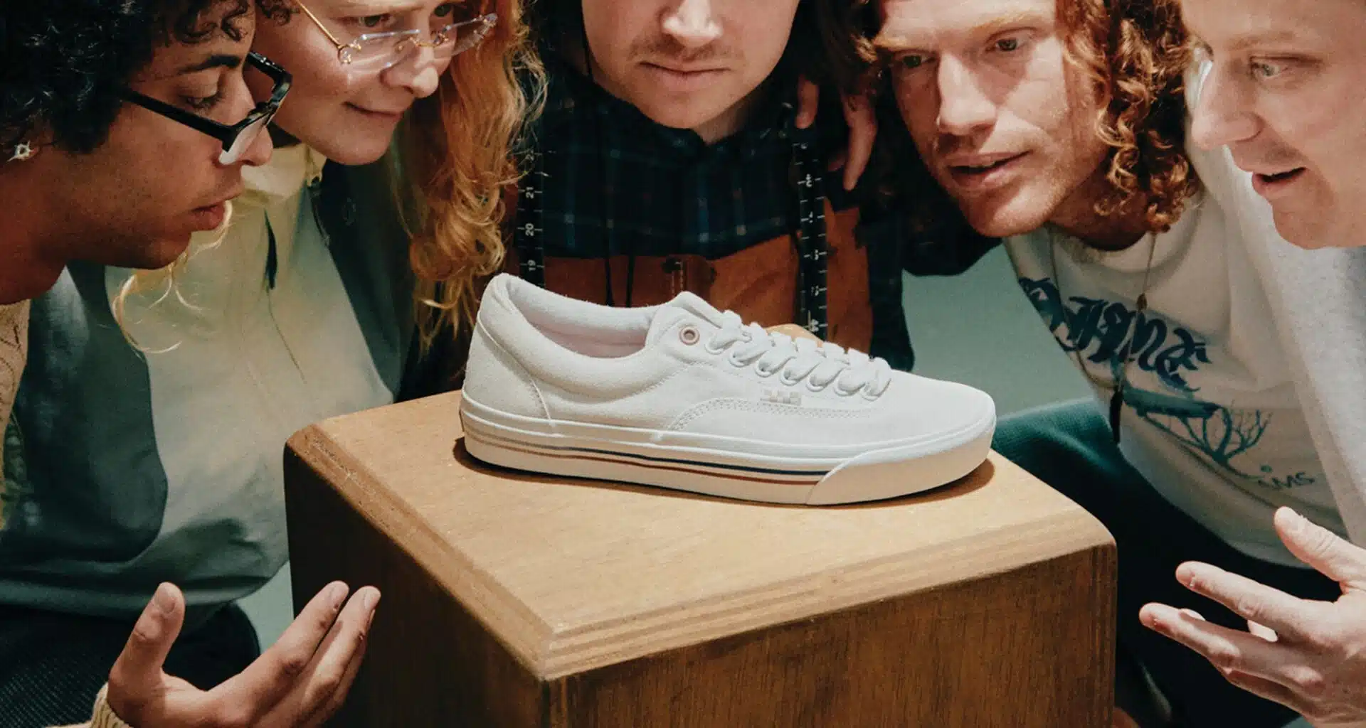 Pessoas observam ténis As novas sapatilhas Vans Skate Era Stub by Dime branco em pedestal.