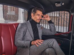 Homem elegante sentado numa viatura clássica.