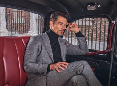 Homem elegante sentado numa viatura clássica.