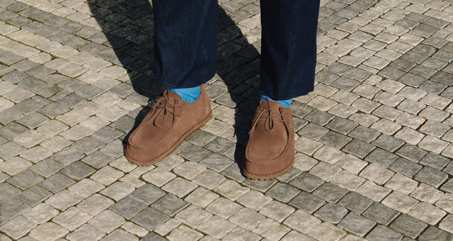 Sapatos castanhos em calçada portuguesa