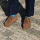 Sapatos castanhos em calçada portuguesa