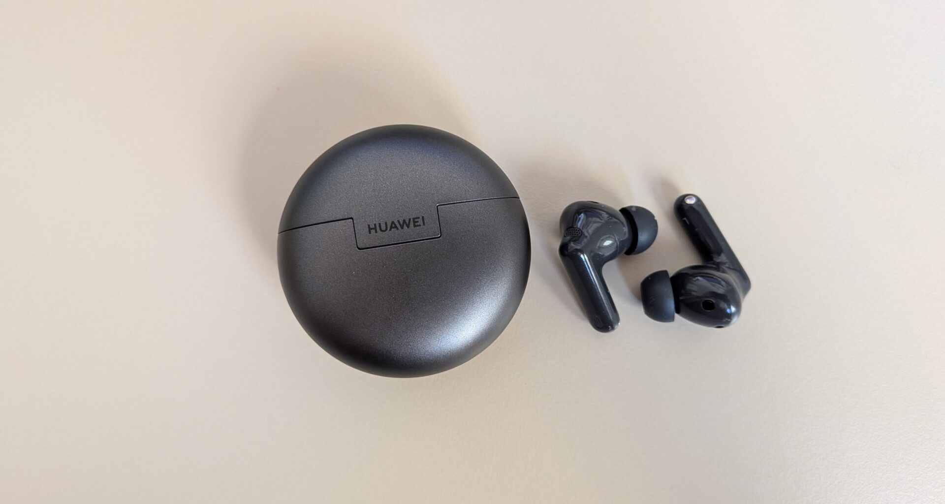 Auriculares Huawei com estojo de carregamento cinzento escuro.