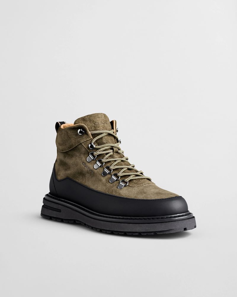 Bota de camurça verde com sola preta robusta.