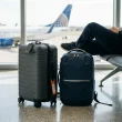 Mala cinzenta e mochila azul num terminal de aeroporto.