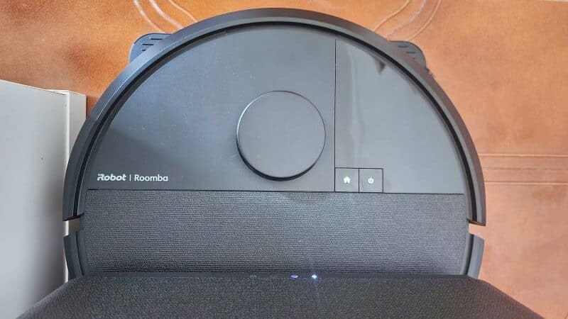 Aspirador robot inteligente sobre tapete castanho.
