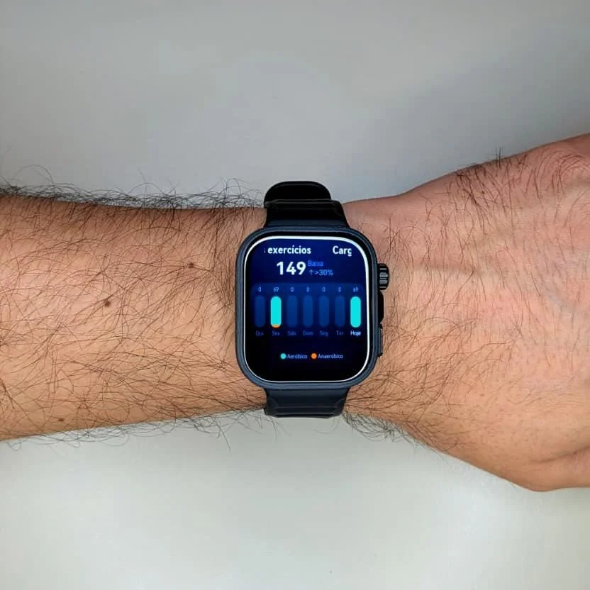 Smartwatch preto no pulso a mostrar estatísticas de fitness.