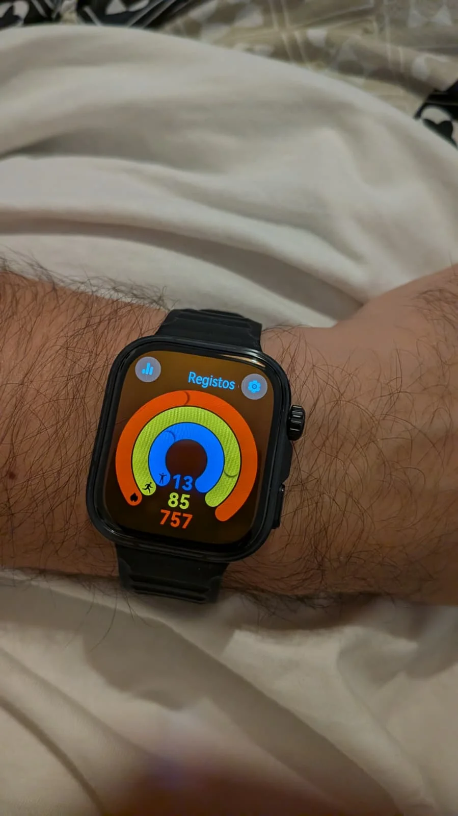 Relógio inteligente no pulso com anéis de atividade fitness.