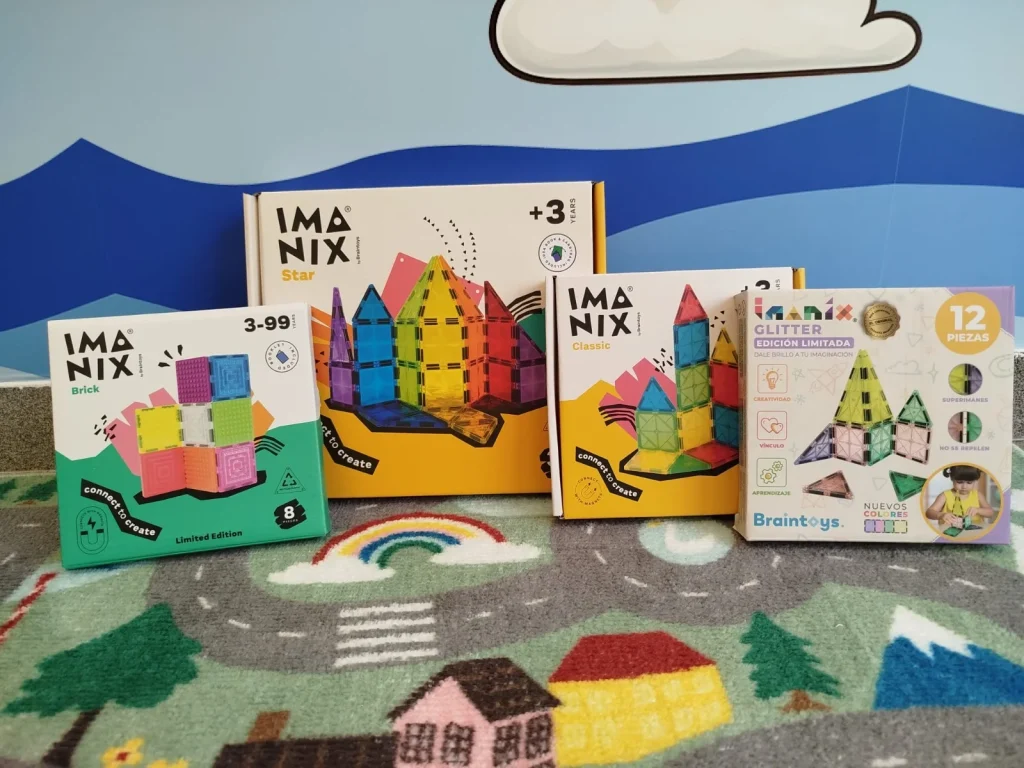 Quatro caixas de brinquedos magnéticos Imanix sobre tapete de atividades.
